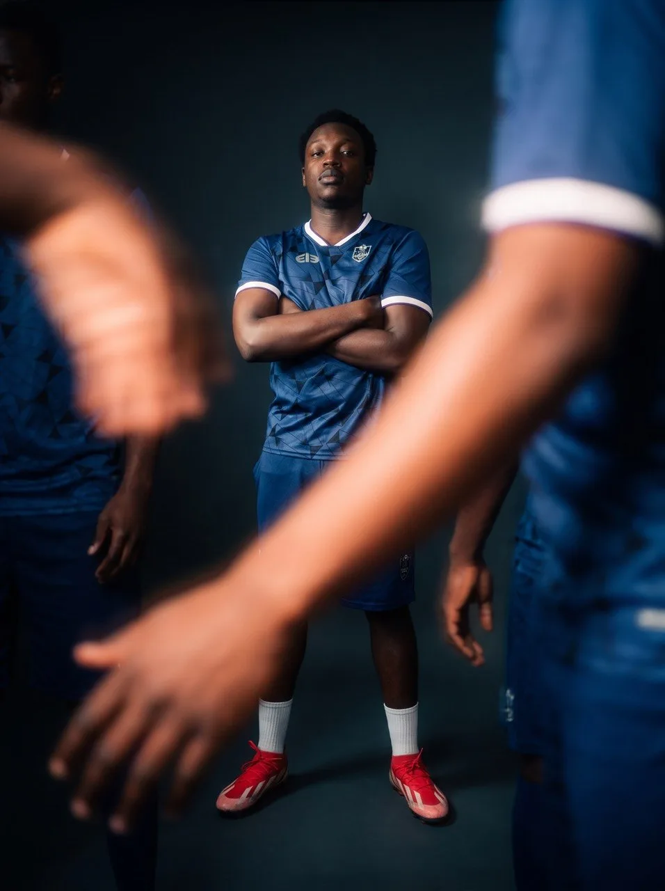 An ACES player in the blue club kit, framed by his teammates